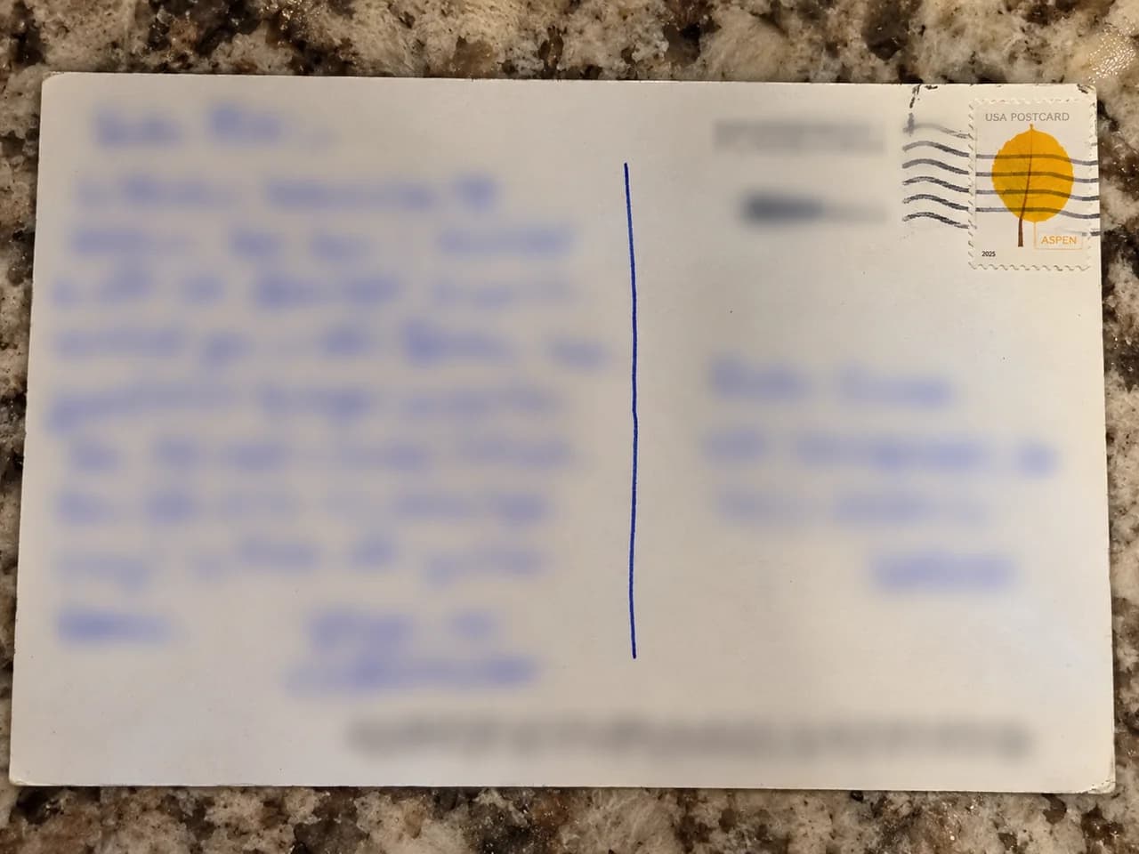 The back of a mailed postcard with the message on the left, address on the right, and all personal writing and the postal barcode blurred