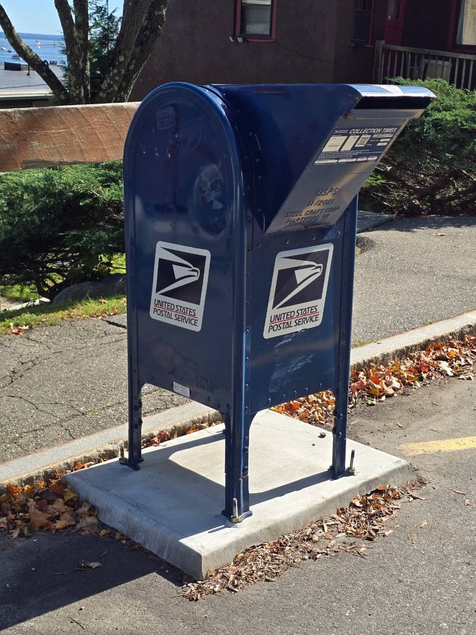 Blue USPS collection box with a mail slot and posted collection times
