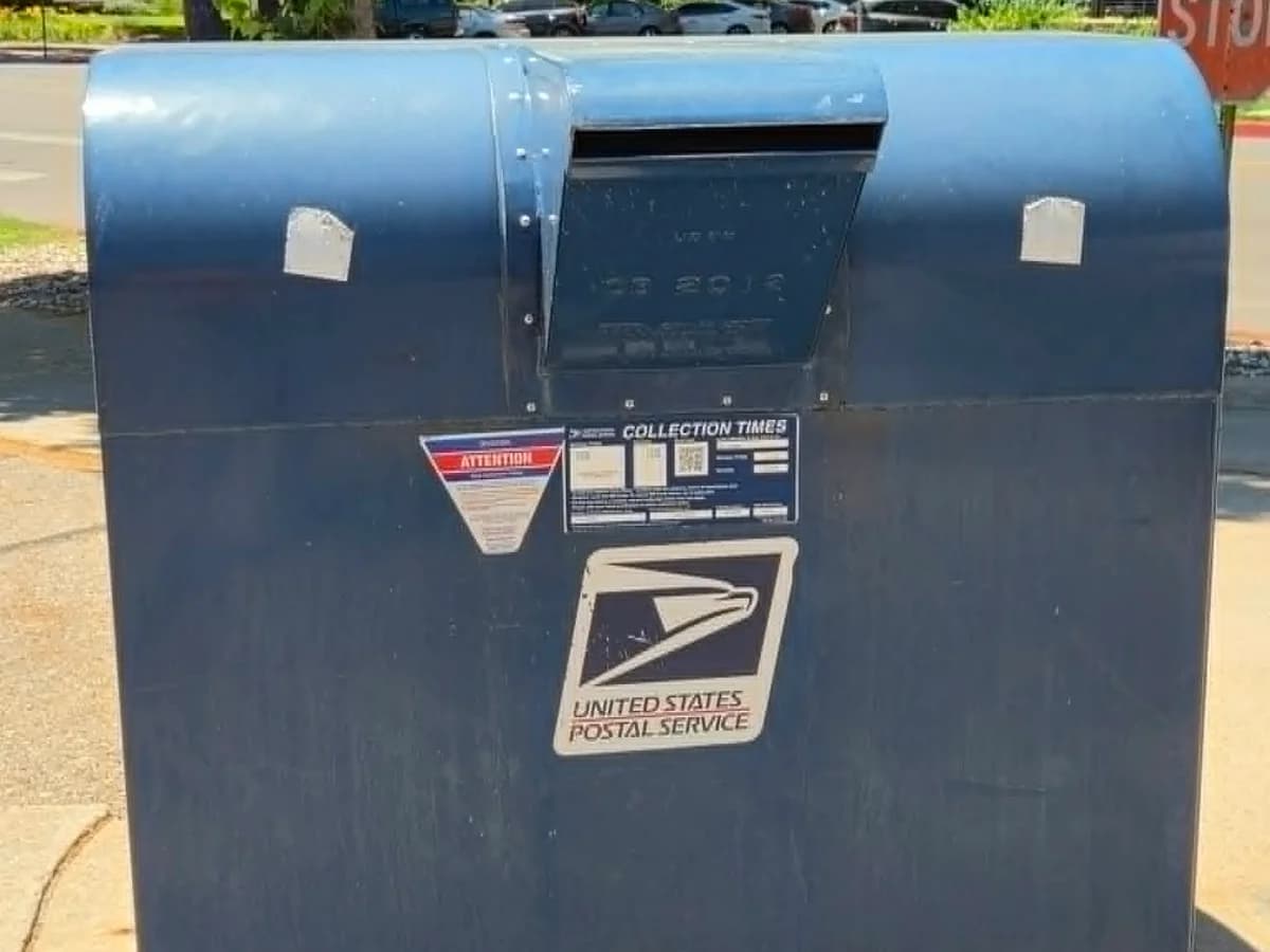 USPS blue collection box with collection times posted on the front