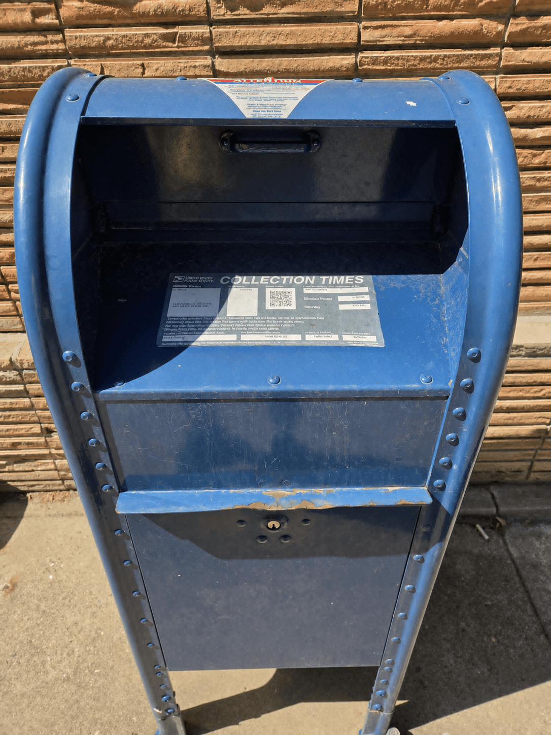 Blue USPS collection box with the posted collection-times panel visible
