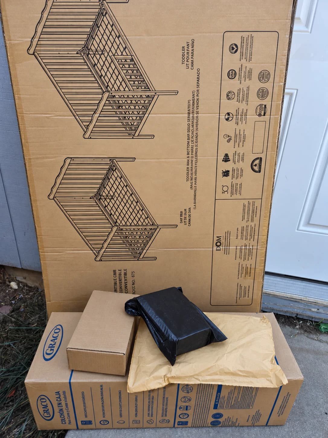Cardboard shipping boxes and filled padded mailers stacked outside a door