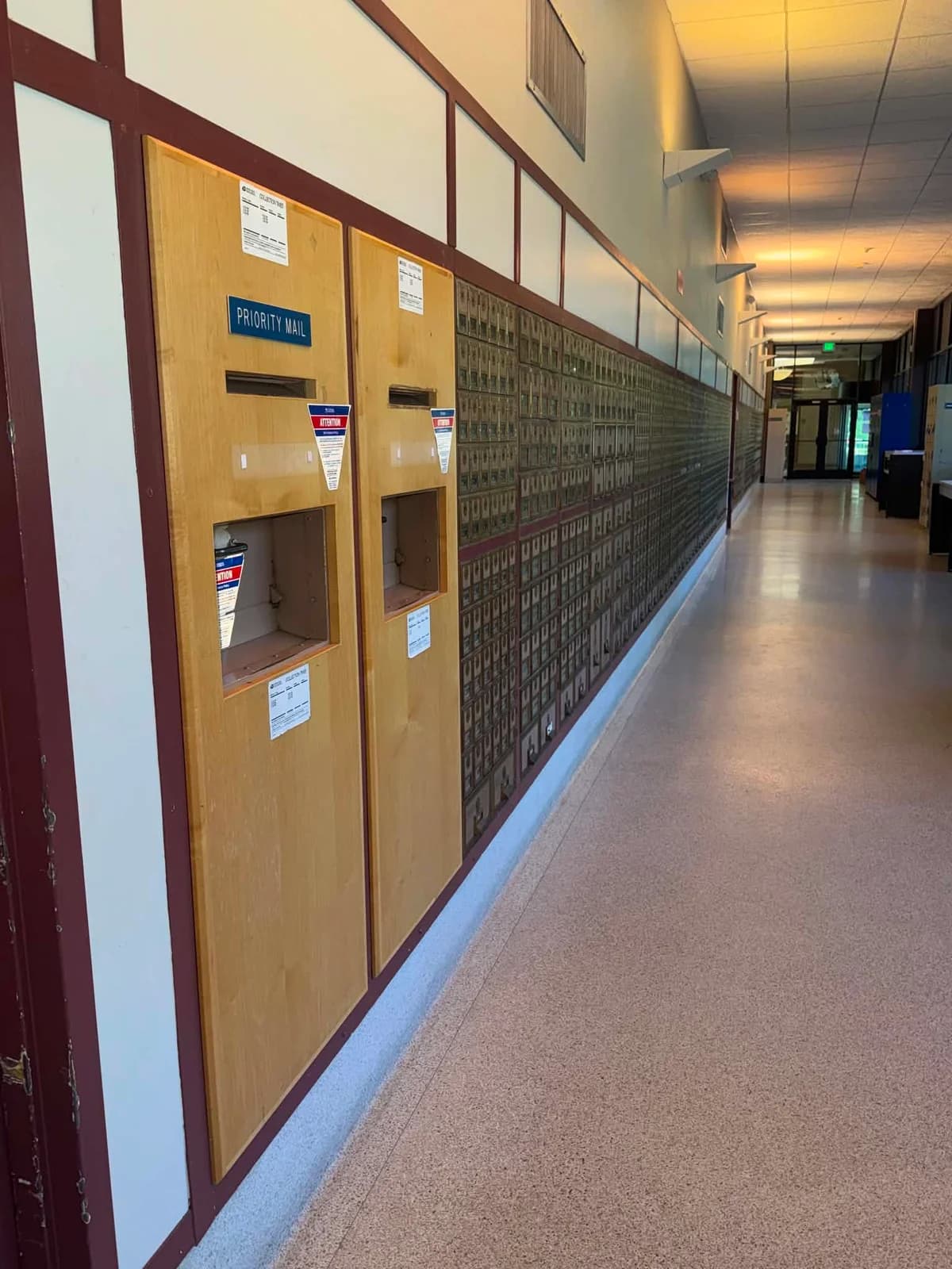 Post Office lobby with mail drop slots beside a long row of PO Boxes