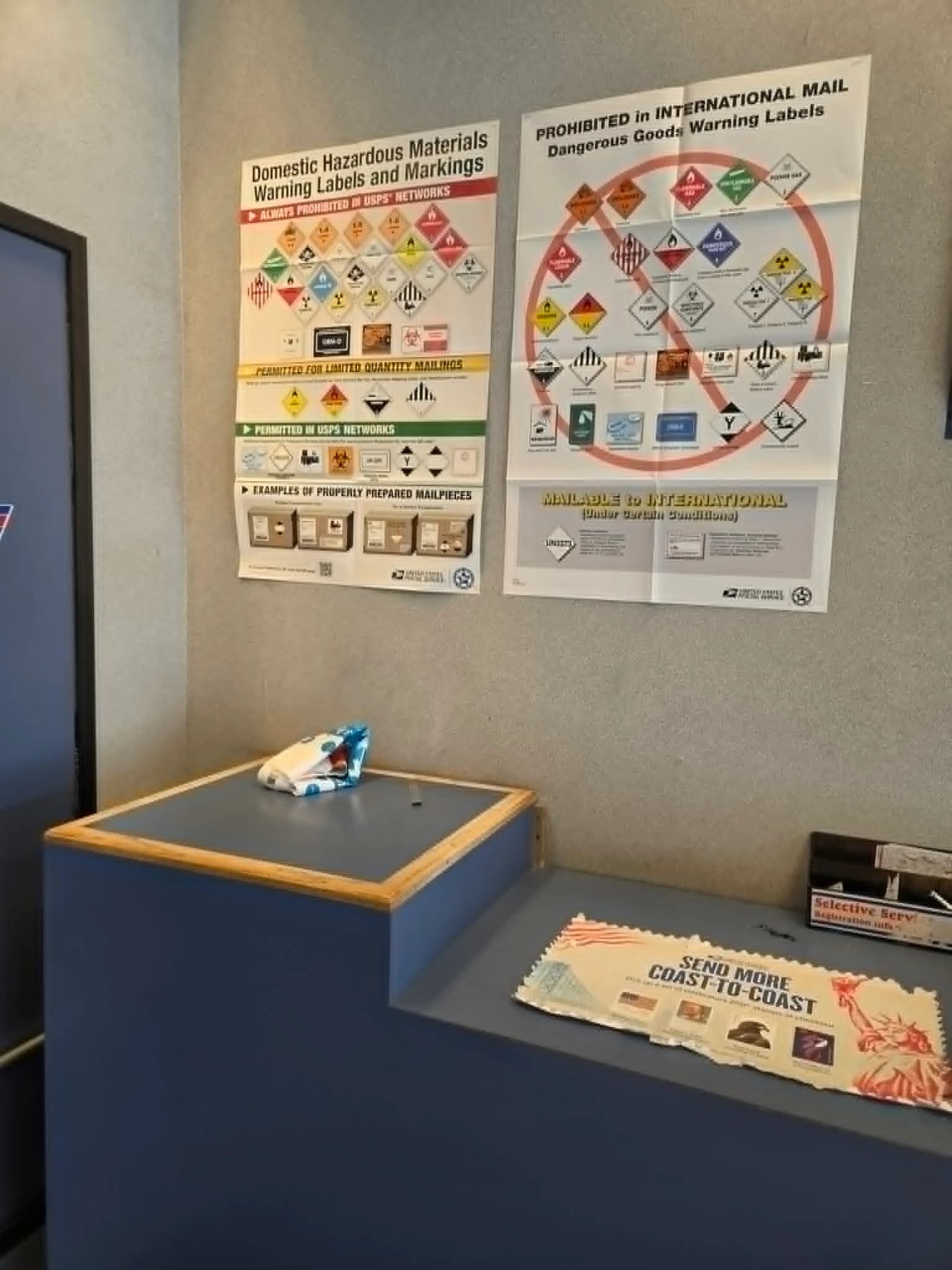 USPS posters showing domestic hazardous-material warning labels and international dangerous-goods restrictions